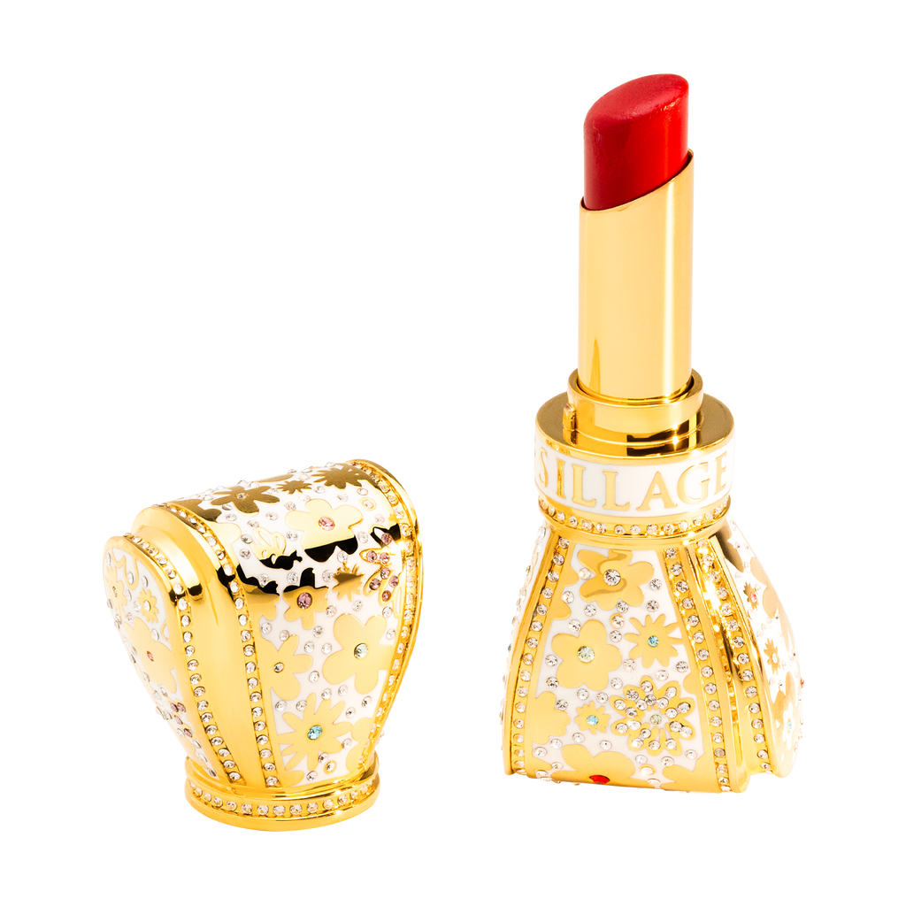 Luxurious red lipstick with gold casing featuring gemstones on a white background