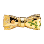 A gold bow lipstick case adorned with pink floral and gecko accents, encrusted with hand-placed Swarovski crystals.
