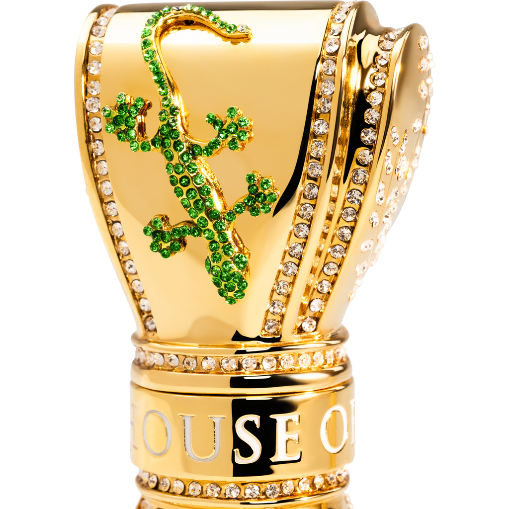 Gold perfume bottle with green gemstone design gecko. 