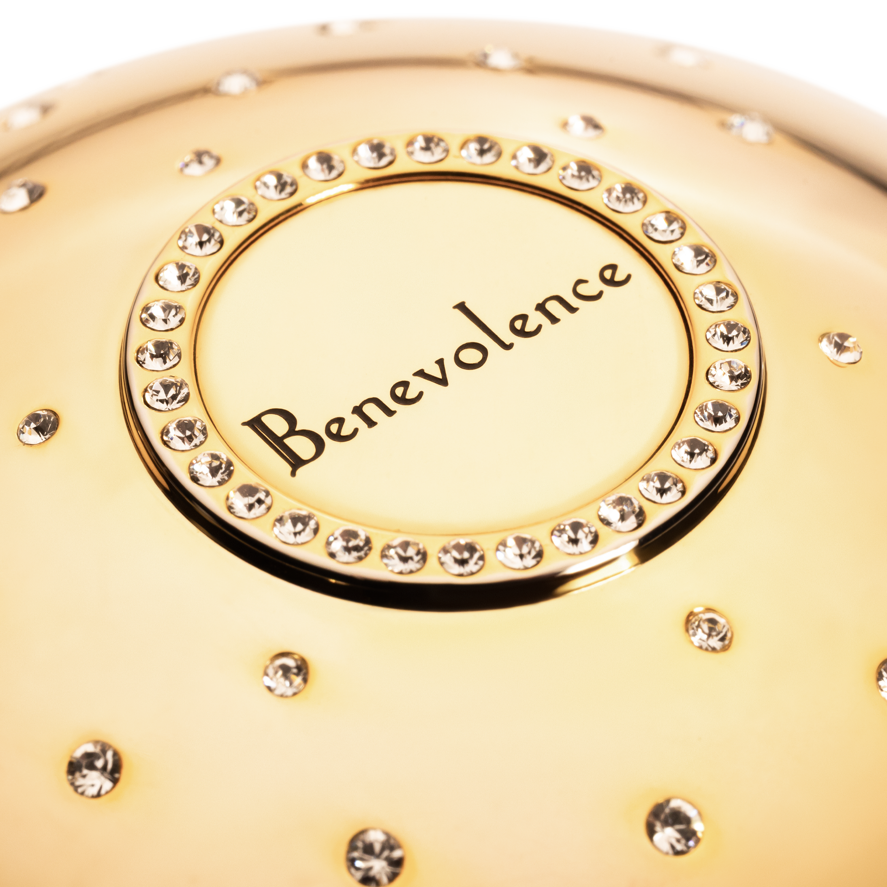 Gold cup of luxury fragrance  with 'Benevolence' branding and crystal embellishments